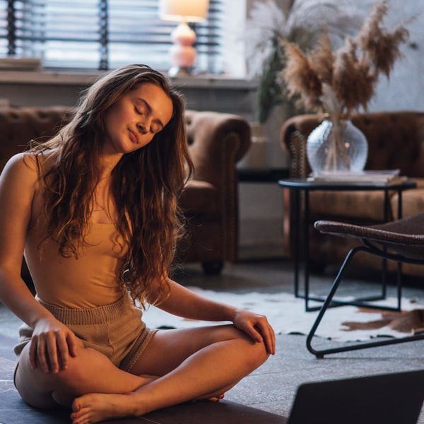 Person stretching gently on a yoga mat at dusk.